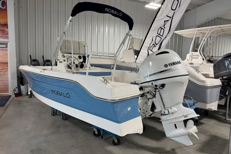 Slide: The Image of 2026 Robalo R160 Center Console boat with Yamaha engine in showroom. - 3