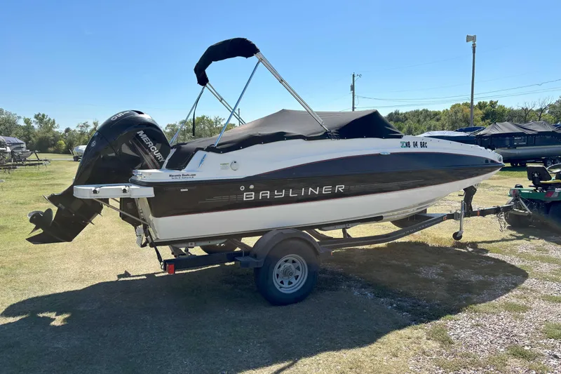Slide: The Image of 2013 Bayliner 190 Deck Boat on trailer, covered and parked outdoors. - 3