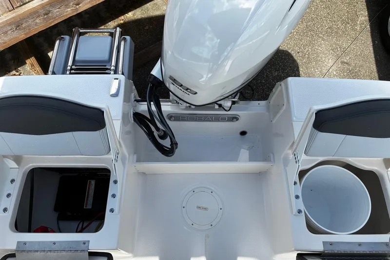 Slide: The Image of 2026 Robalo R160 Center Console boat interior with storage compartments and outboard motor. - 10