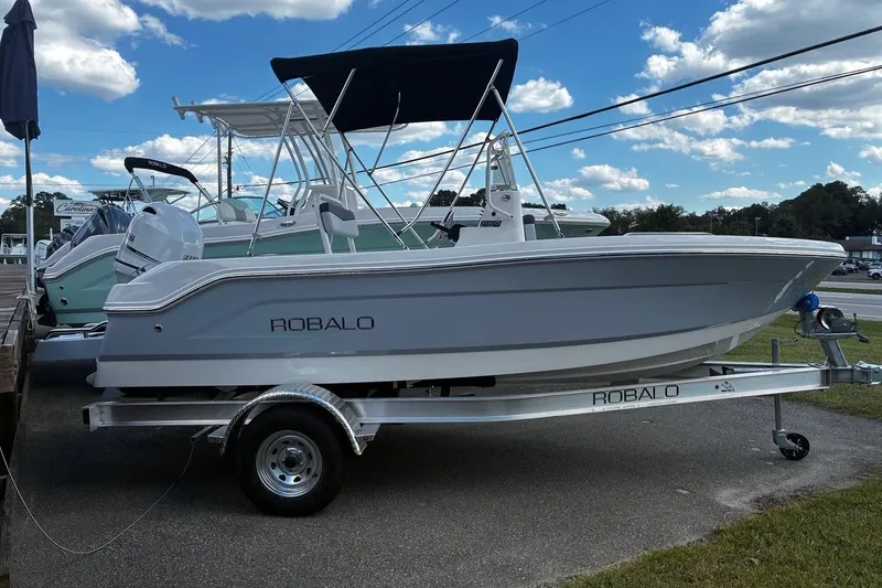Slide: The Image of 2026 Robalo R160 Center Console boat on trailer under blue sky. - 3