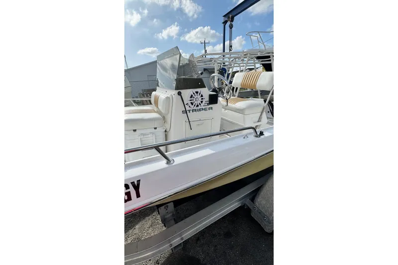 Slide: The Image of 1997 Seaswirl 1730 CC Striper boat with seating and steering console, docked outdoors. - 13