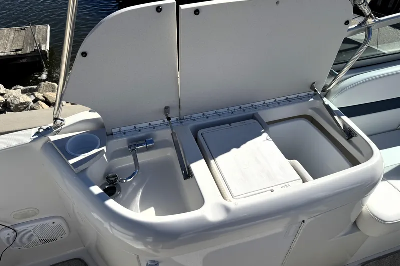 Slide: The Image of 2000 Formula 260 Bowrider boat sink and storage area with open lid. - 11