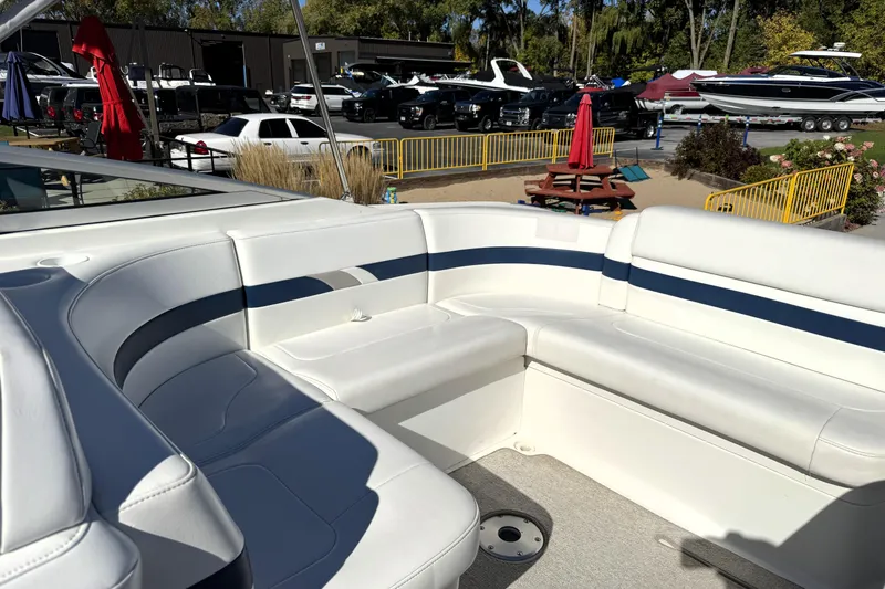 Slide: The Image of 2000 Formula 260 Bowrider boat interior with white seating, parked at a marina. - 12