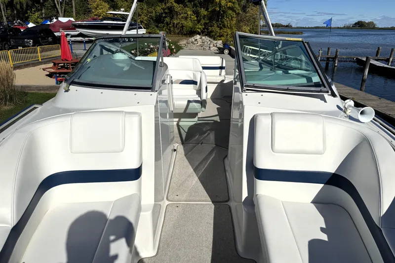 Slide: The Image of 2000 Formula 260 Bowrider boat interior with white seating, dockside view. - 24