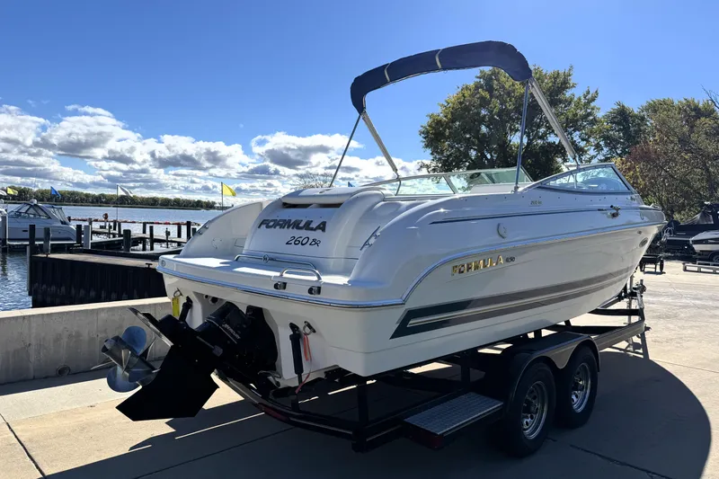 Slide: The Image of 2000 Formula 260 Bowrider boat on trailer by a lakeside dock. - 4
