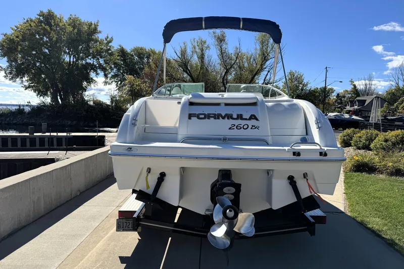 Slide: The Image of 2000 Formula 260 Bowrider boat on trailer, parked near water, sunny day. - 6