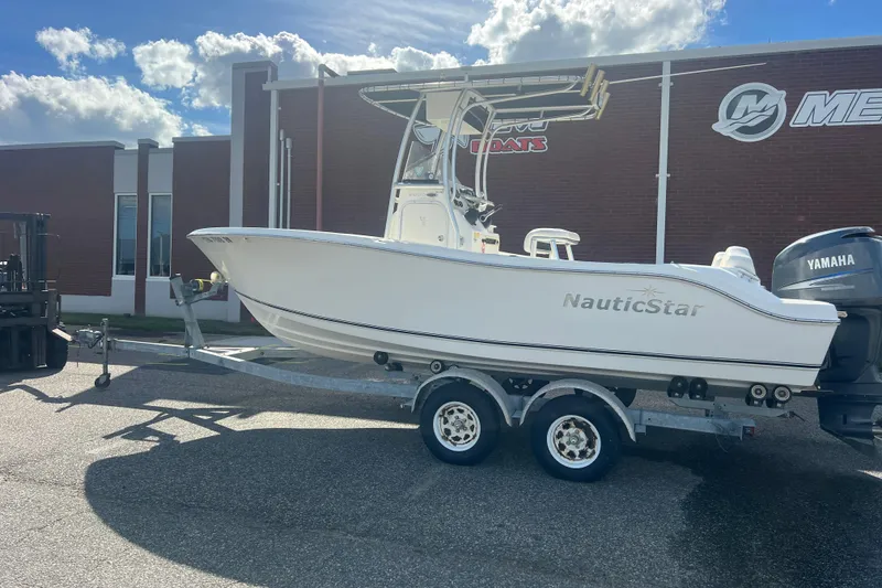 Slide: The Image of 2007 NauticStar 2000 Offshore boat on trailer, parked outside a building. - 2