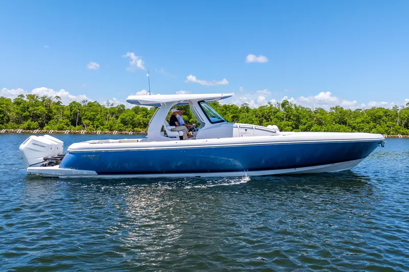 The Image of 2025 Intrepid 41 Panacea boat cruising on a sunny day, surrounded by lush greenery. - 0