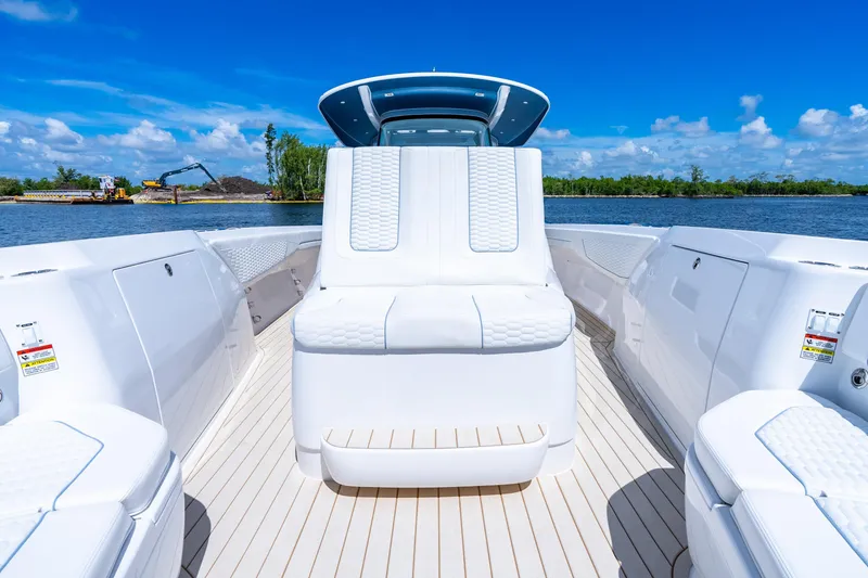 Slide: The Image of 2025 Intrepid 41 Panacea boat interior with white seating, on a sunny day by the water. - 26