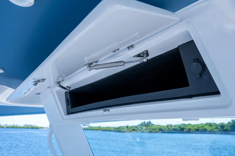 Slide: The Image of Open storage compartment on 2025 Intrepid 41 Panacea boat, with ocean view background. - 42