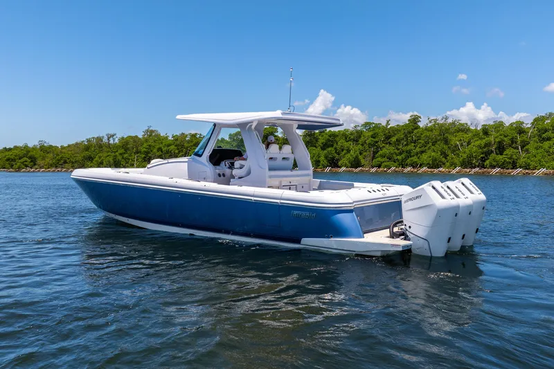 Slide: The Image of 2025 Intrepid 41 Panacea boat on water, blue hull, triple outboard engines, clear sky. - 5