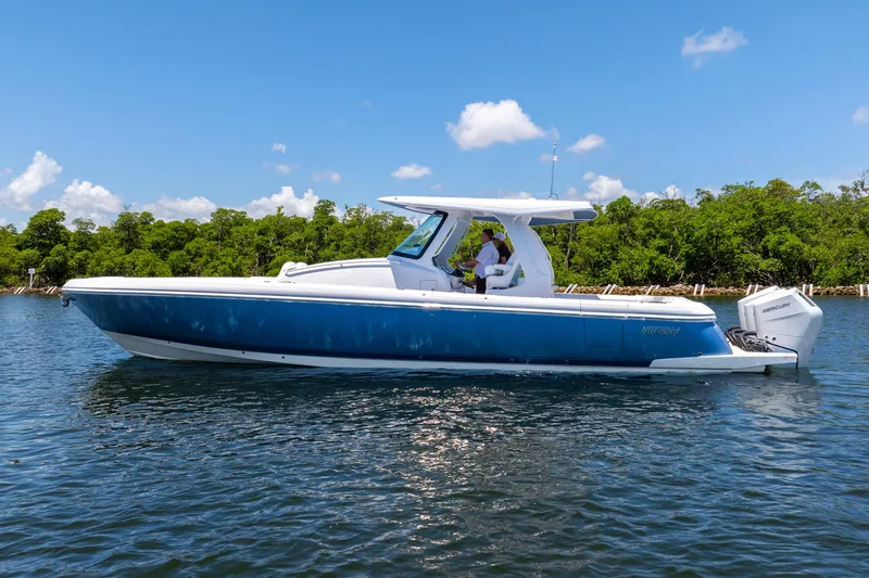 Slide: The Image of 2025 Intrepid 41 Panacea boat on water, clear sky, lush green background. - 6