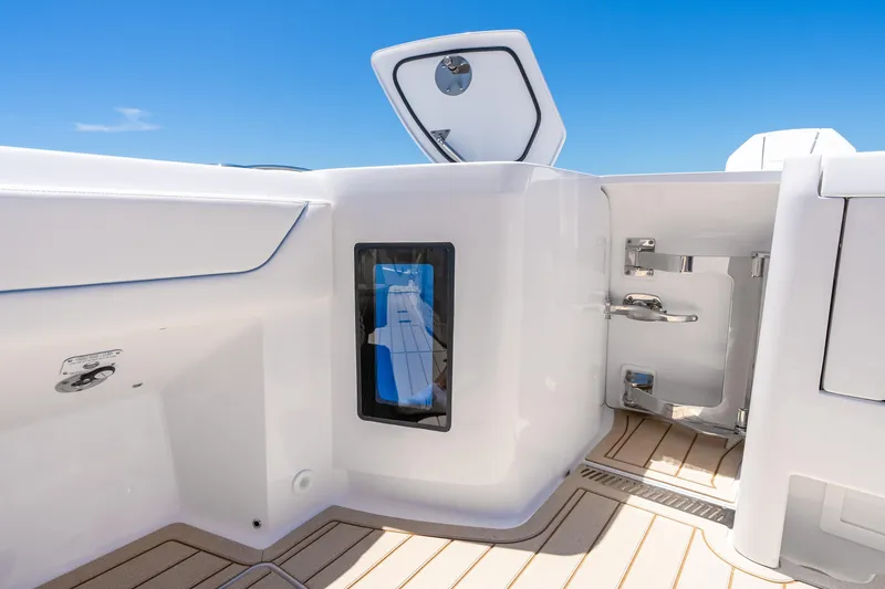 Slide: The Image of 2025 Intrepid 41 Panacea boat interior with open storage compartment, sleek design, and blue sky. - 74