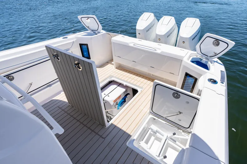 Slide: The Image of 2025 Intrepid 41 Panacea boat deck with open storage compartments and powerful outboard engines. - 77