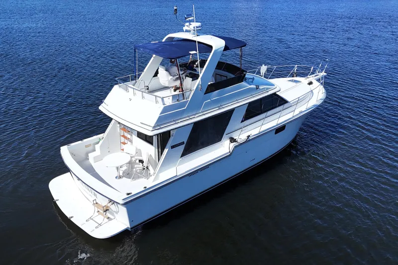 Slide: The Image of 1987 Carver 4227 Cockpit Motor Yacht on calm blue water, aerial view. - 0
