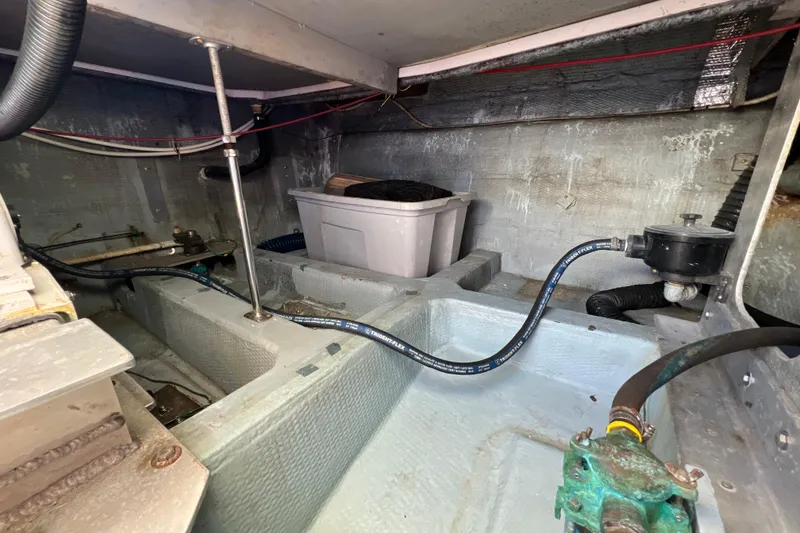 Slide: The Image of Engine compartment of 1987 Carver 4227 Cockpit Motor Yacht, showing hoses and storage bin. - 100
