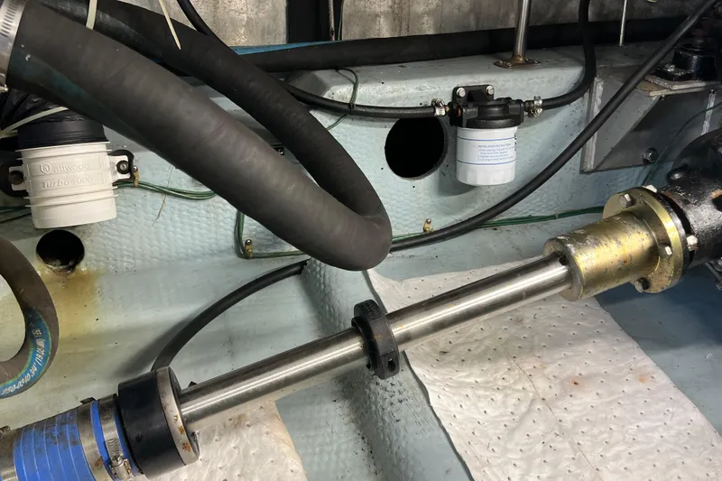 Slide: The Image of Engine compartment of 1987 Carver 4227 Cockpit Motor Yacht with visible hoses and components. - 104