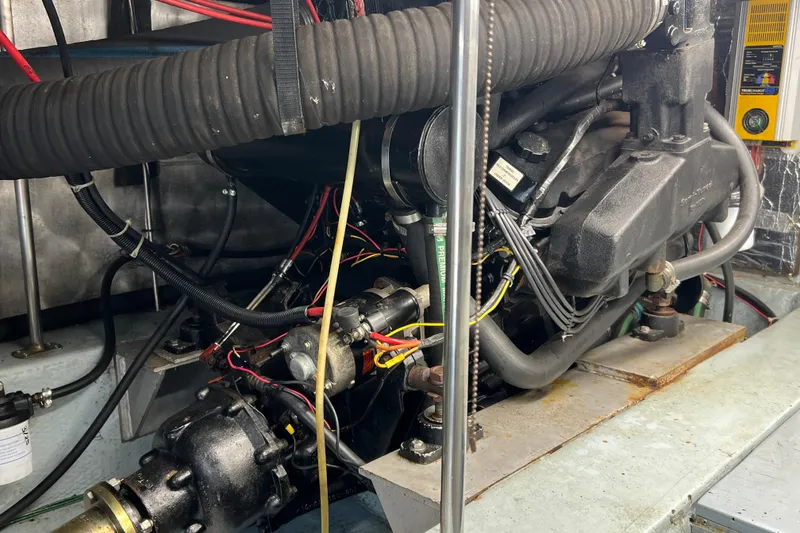 Slide: The Image of Engine room of 1987 Carver 4227 Cockpit Motor Yacht with visible components and wiring. - 105