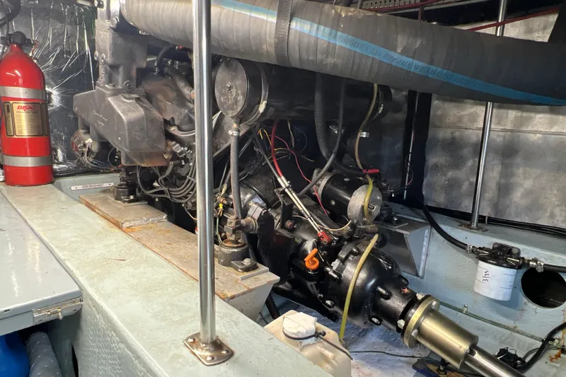 Slide: The Image of Engine room of 1987 Carver 4227 Cockpit Motor Yacht with visible machinery and fire extinguisher. - 107