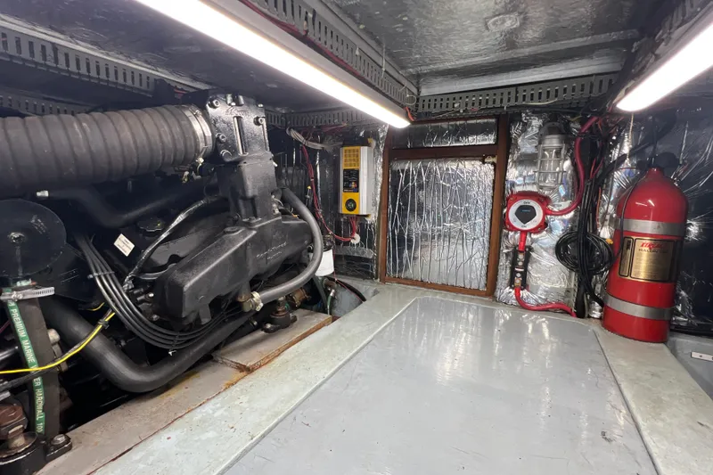 Slide: The Image of Engine room of 1987 Carver 4227 Cockpit Motor Yacht with fire extinguisher and machinery. - 108