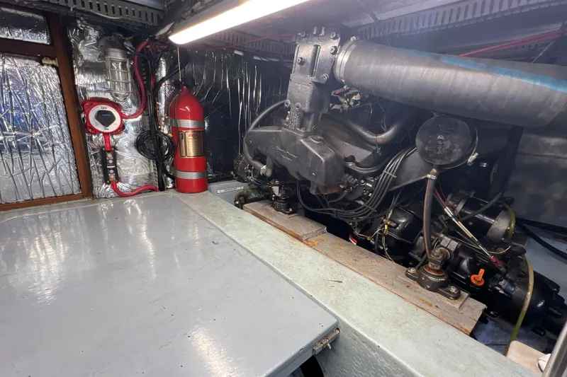 Slide: The Image of Engine room of 1987 Carver 4227 Cockpit Motor Yacht with visible fire extinguisher. - 109