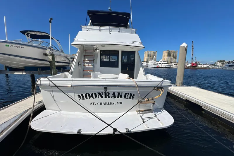 Slide: The Image of 1987 Carver 4227 Cockpit Motor Yacht "Moonraker" docked at marina, clear blue sky. - 11