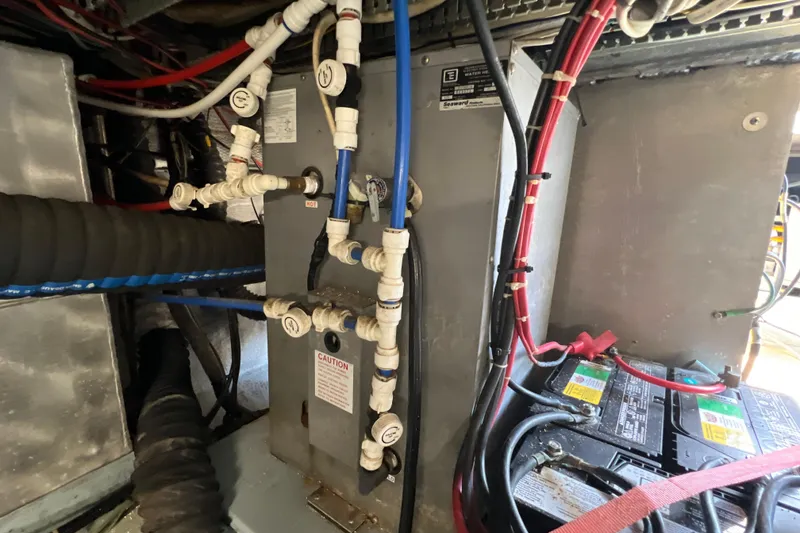 Slide: The Image of Engine room of 1987 Carver 4227 Cockpit Motor Yacht with wiring and plumbing. - 114