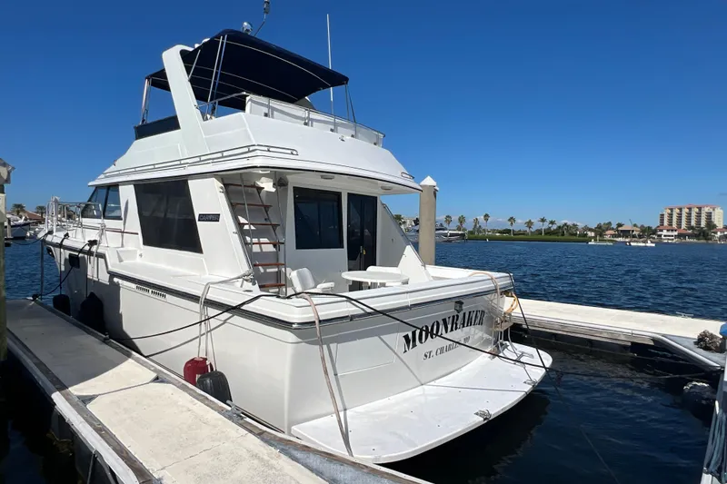 Slide: The Image of 1987 Carver 4227 Cockpit Motor Yacht docked at marina under clear blue sky. - 12