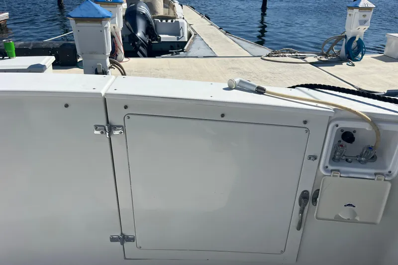 Slide: The Image of 1987 Carver 4227 Cockpit Motor Yacht docked, showing deck and water hose. - 15