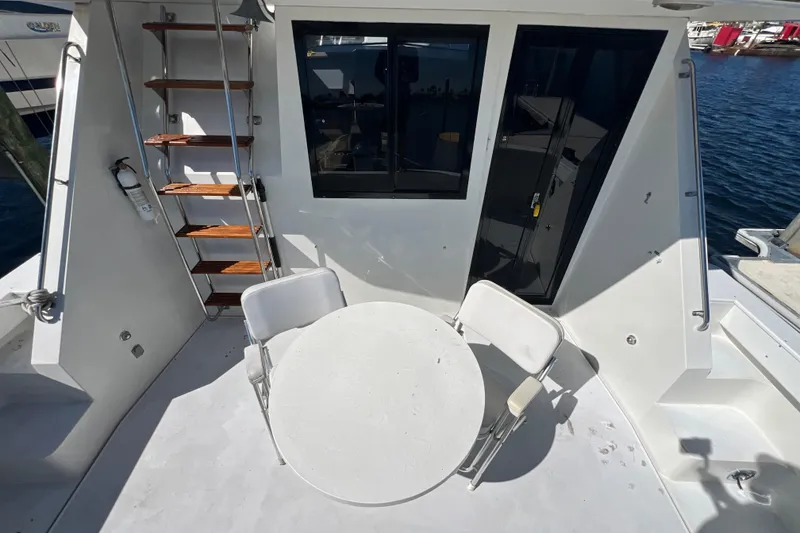 Slide: The Image of 1987 Carver 4227 Cockpit Motor Yacht with outdoor seating and wooden steps. - 18