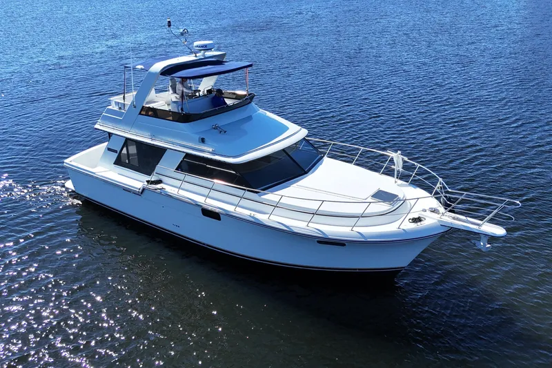 Slide: The Image of 1987 Carver 4227 Cockpit Motor Yacht cruising on calm blue waters. - 2