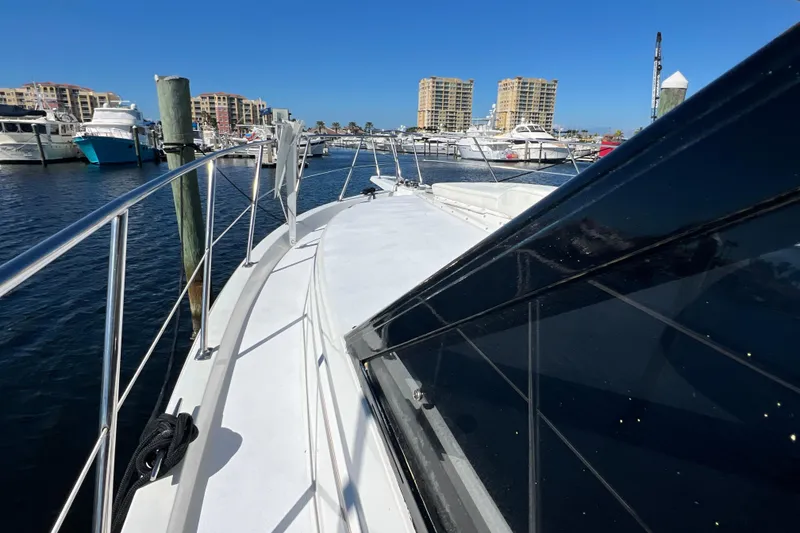 Slide: The Image of 1987 Carver 4227 Cockpit Motor Yacht docked in a marina with cityscape background. - 22