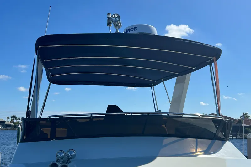 Slide: The Image of 1987 Carver 4227 Cockpit Motor Yacht with blue canopy under clear sky. - 28