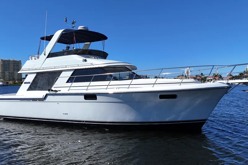 Slide: The Image of 1987 Carver 4227 Cockpit Motor Yacht on water, clear blue sky background. - 3