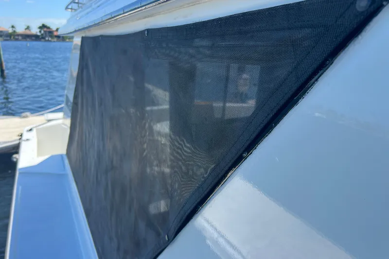 Slide: The Image of 1987 Carver 4227 Cockpit Motor Yacht with mesh window cover, docked by the water. - 31