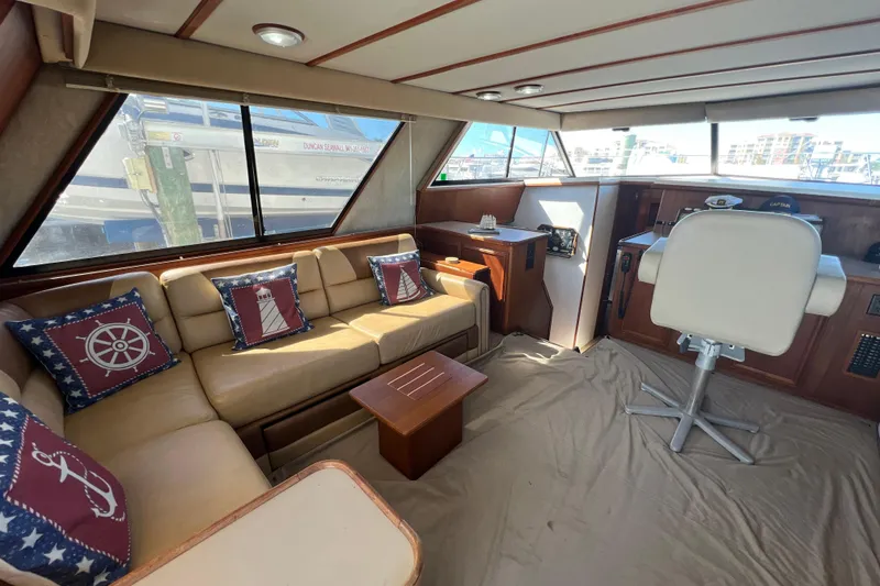 Slide: The Image of Interior of 1987 Carver 4227 Cockpit Motor Yacht with beige seating and nautical-themed pillows. - 35