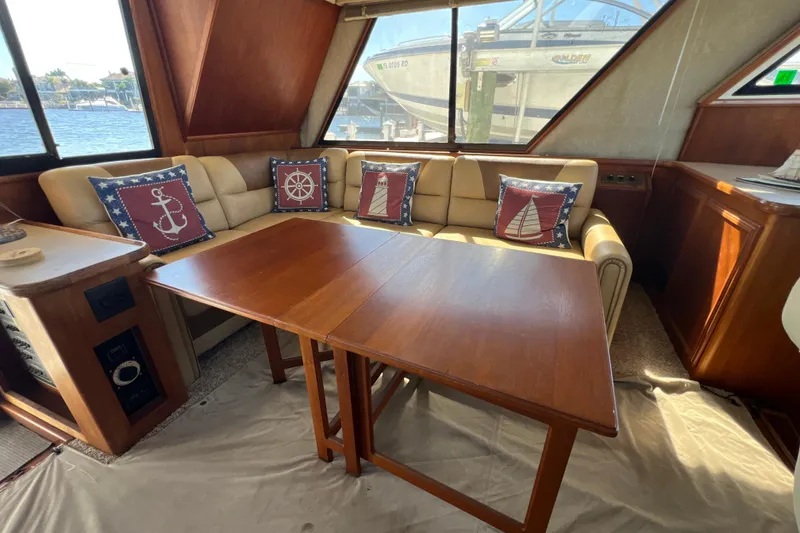 Slide: The Image of Interior of 1987 Carver 4227 Cockpit Motor Yacht with nautical-themed cushions and wooden table. - 39