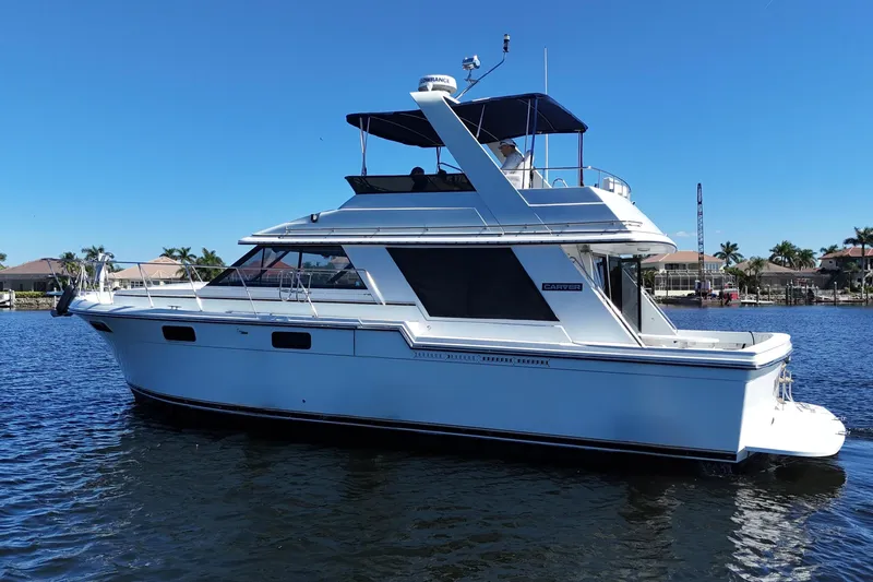 Slide: The Image of 1987 Carver 4227 Cockpit Motor Yacht on calm water under clear blue sky. - 4