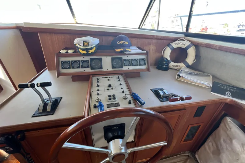 Slide: The Image of 1987 Carver 4227 Cockpit Motor Yacht helm with captain's hat and nautical instruments. - 48