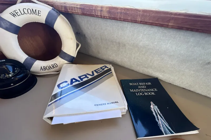 Slide: The Image of Carver 4227 Cockpit Motor Yacht manuals and log book on a boat's dashboard. - 49