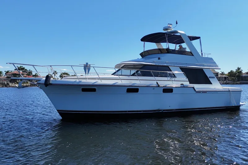 Slide: The Image of 1987 Carver 4227 Cockpit Motor Yacht on calm water, clear sky background. - 5