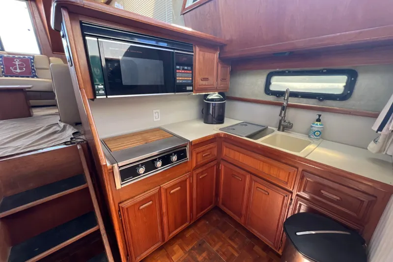 Slide: The Image of 1987 Carver 4227 Cockpit Motor Yacht kitchen with wood cabinetry and modern appliances. - 54