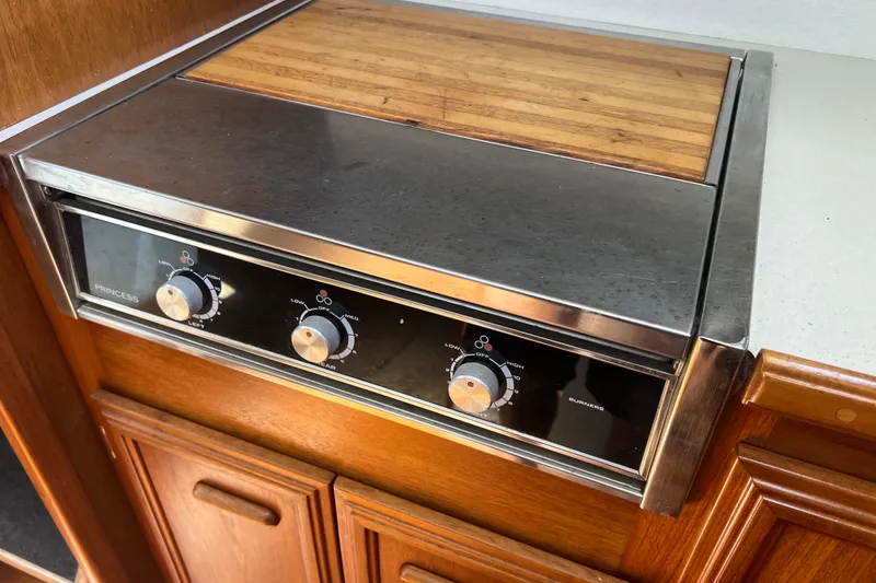 Slide: The Image of Stainless steel stove with wooden cutting board on 1987 Carver 4227 Cockpit Motor Yacht. - 55