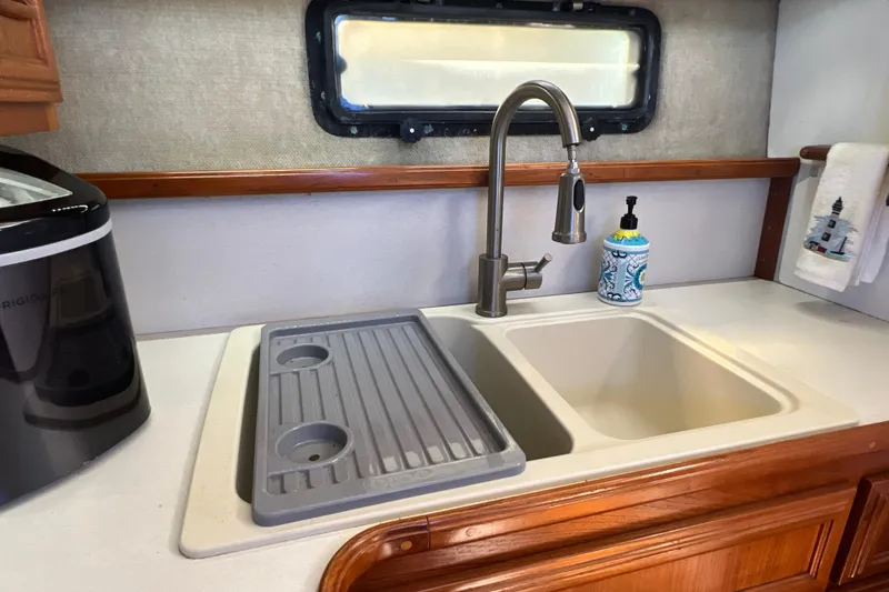 Slide: The Image of 1987 Carver 4227 Cockpit Motor Yacht kitchen sink with faucet and countertop accessories. - 56