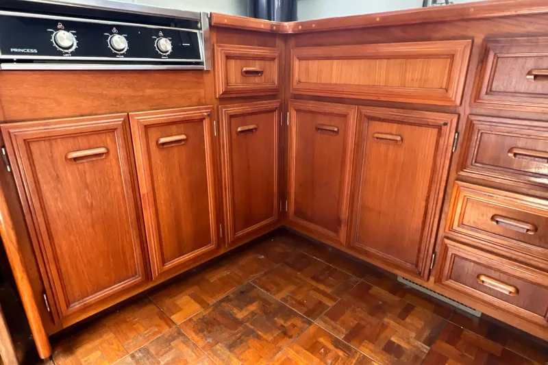 Slide: The Image of Wooden cabinetry in 1987 Carver 4227 Cockpit Motor Yacht kitchen, featuring a Princess stove. - 57