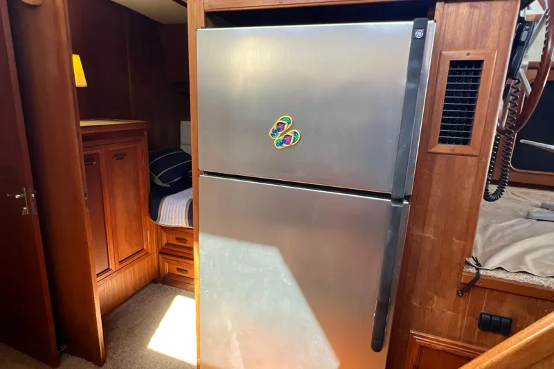Slide: The Image of 1987 Carver 4227 Cockpit Motor Yacht interior with stainless steel refrigerator. - 58