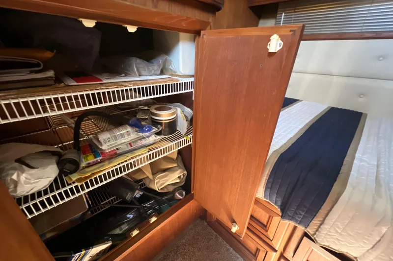 Slide: The Image of Interior storage of 1987 Carver 4227 Cockpit Motor Yacht with open cabinet and shelves. - 62