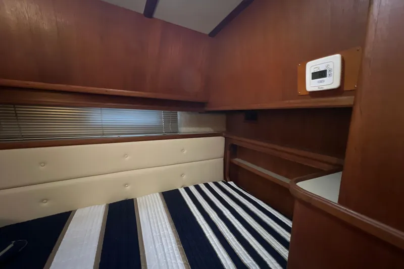 Slide: The Image of Interior of 1987 Carver 4227 Cockpit Motor Yacht with wood paneling and striped bedding. - 63
