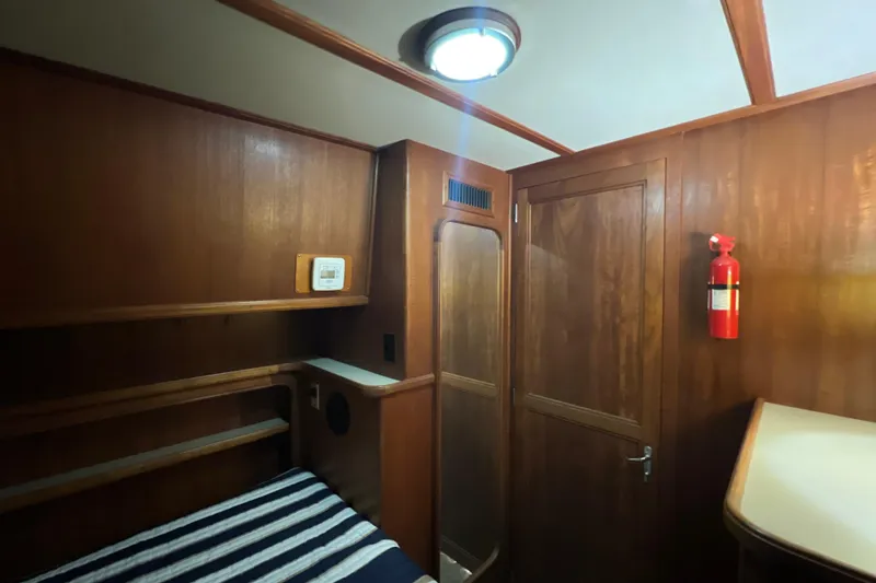 Slide: The Image of Interior of 1987 Carver 4227 Cockpit Motor Yacht with wood paneling and fire extinguisher. - 64