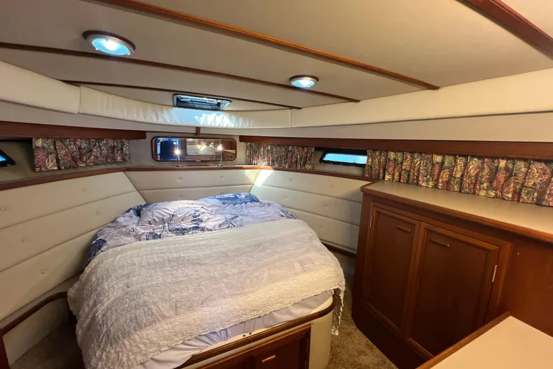 Slide: The Image of Cozy bedroom in 1987 Carver 4227 Cockpit Motor Yacht with wood cabinetry and patterned curtains. - 65
